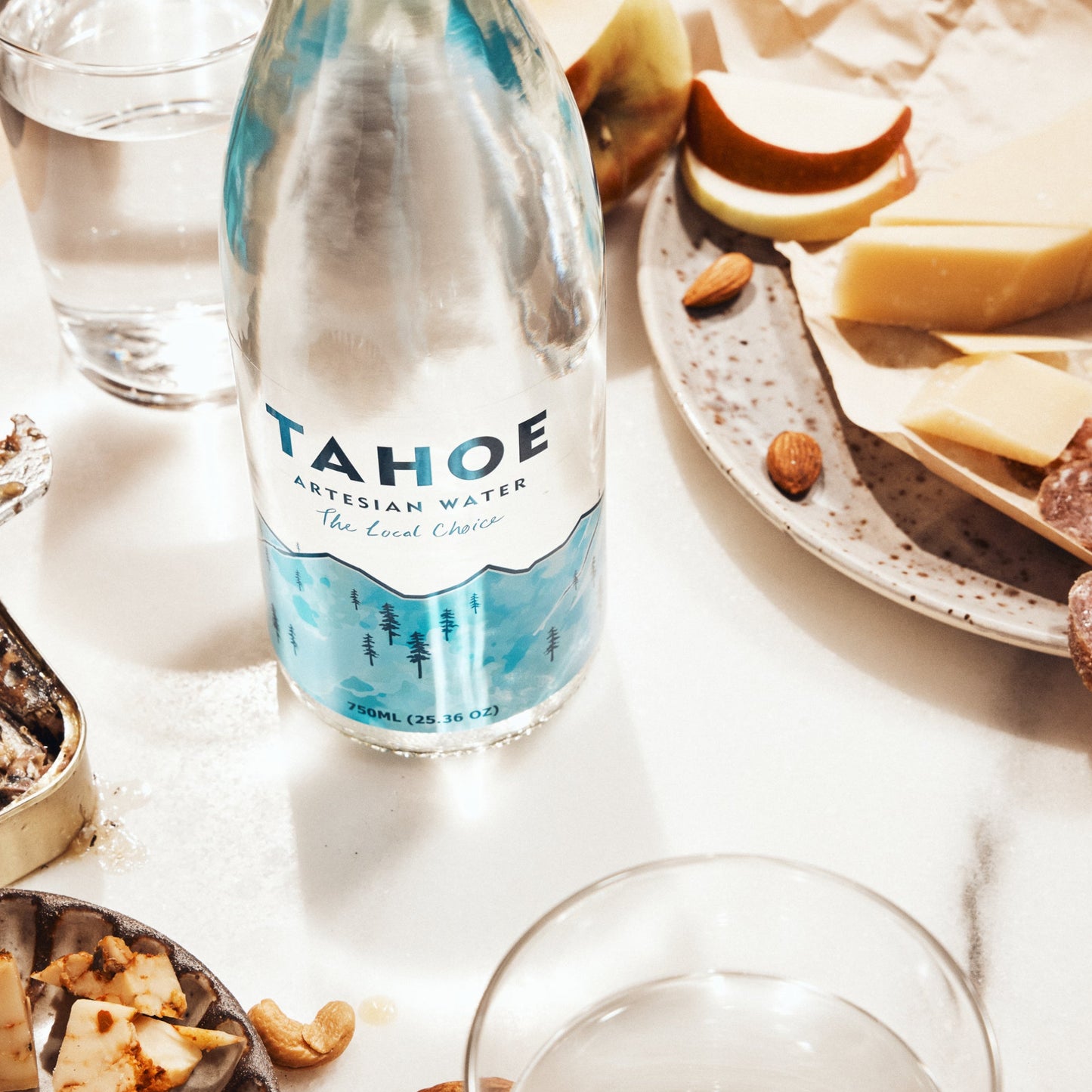 Bottle of Tahoe water on a table with snacks and glasses