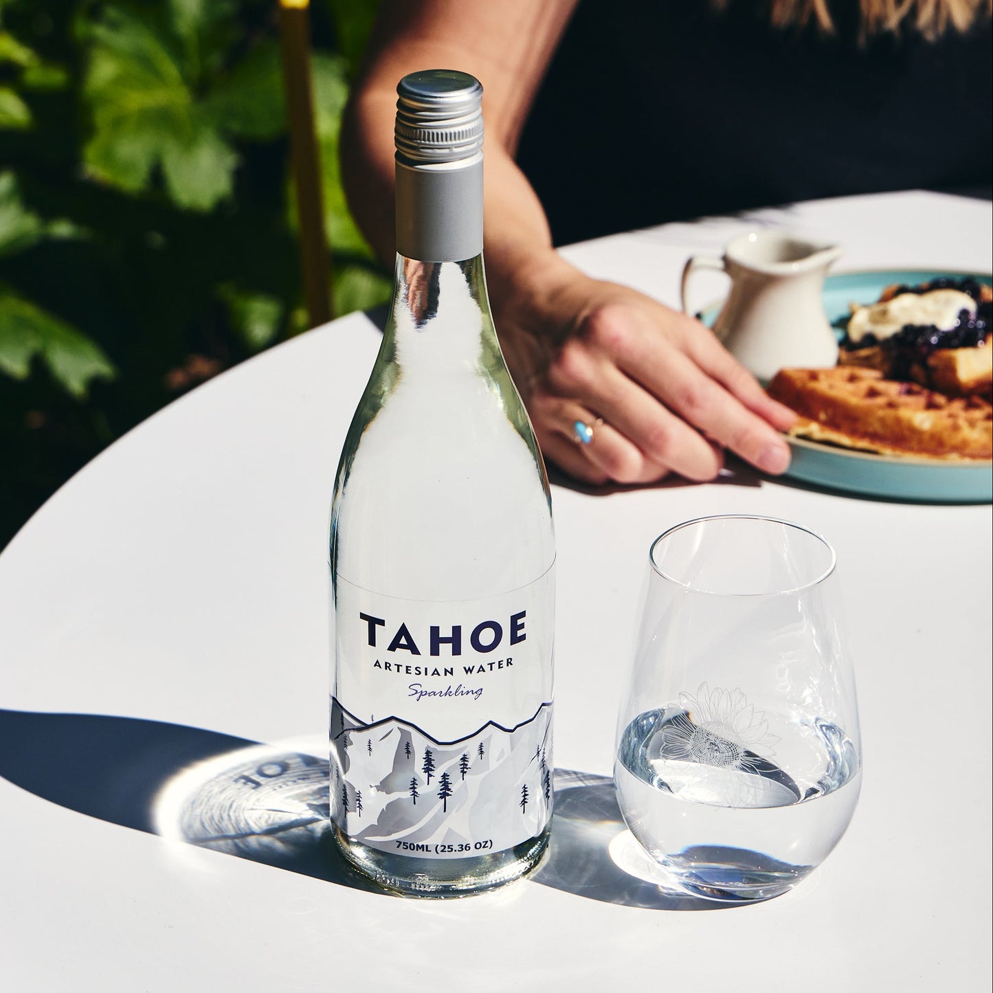 
                  
                    Bottle of Tahoe Artesian water on a table with a person in the background
                  
                